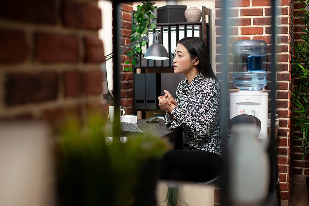 A content marketer listening to an online meeting session from an office room.